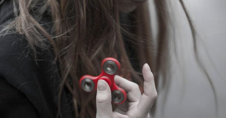 Trends - Woman Holding Red Hand Spinner