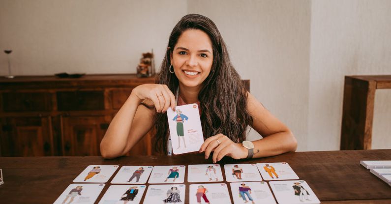 Styles - Brunette Woman Sitting behind Table with Fashion Cards
